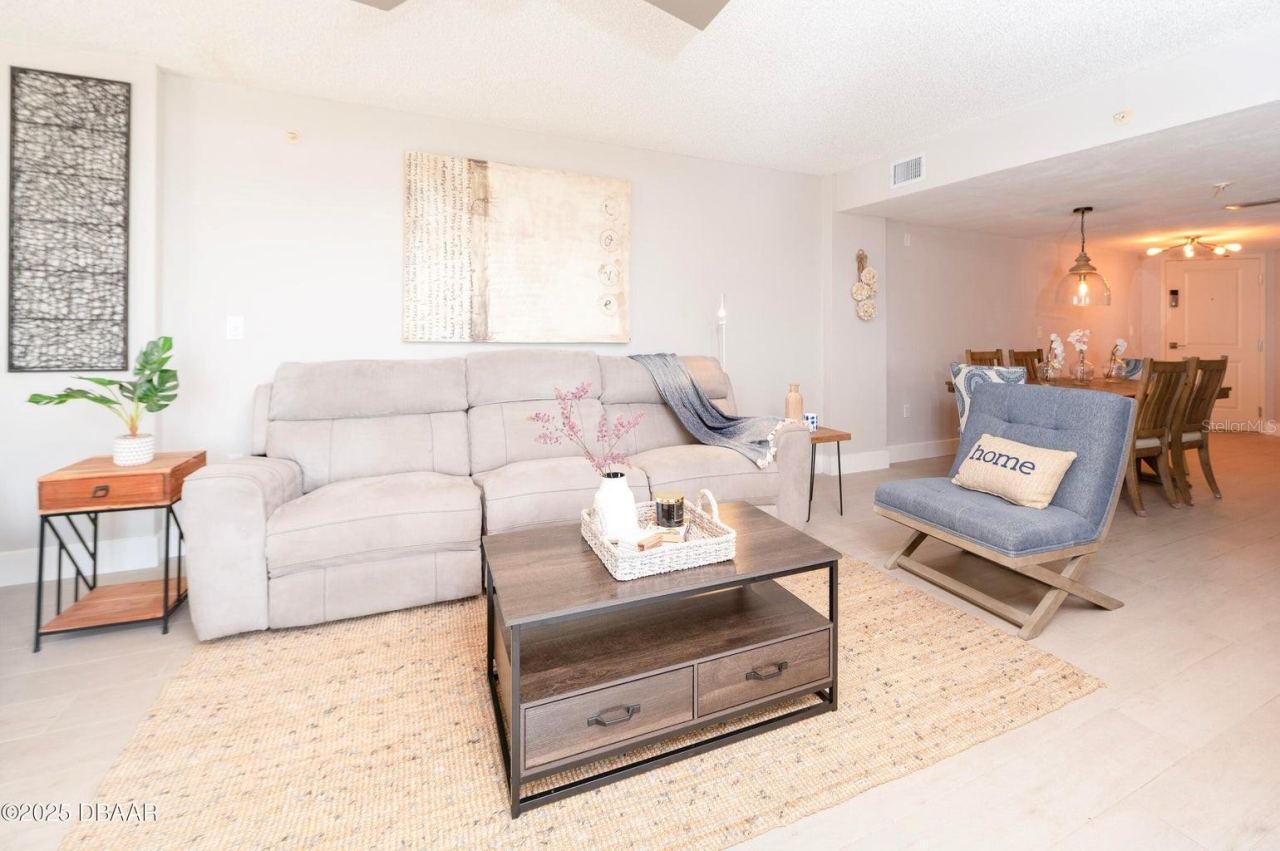 Photo 14 of 20: This inviting living room offers a comfortable gathering space with neutral finishes and an open connection to the dining area, ideal for relaxing after a day at the beach.