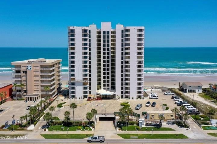 Photo 3 of 20: The building's clean façade and gated entrance welcome residents with manicured landscaping, ample parking, and ocean views from every level.