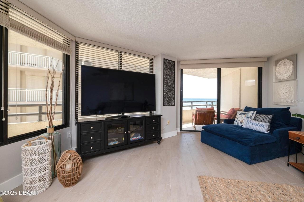 Photo 15 of 20: This bright and inviting living room features expansive windows and sliding glass doors opening to the private balcony, where beautiful Atlantic Ocean views await.
