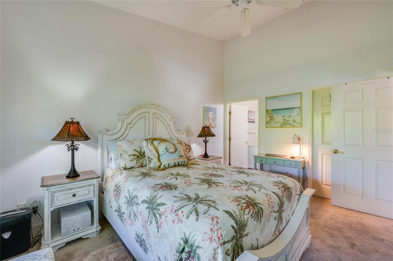 Photo 12 of 20: Well-proportioned bedroom with high ceilings, neutral carpet, and soft wall colors. Open doorways lead directly into an en-suite bathroom and a private closet.