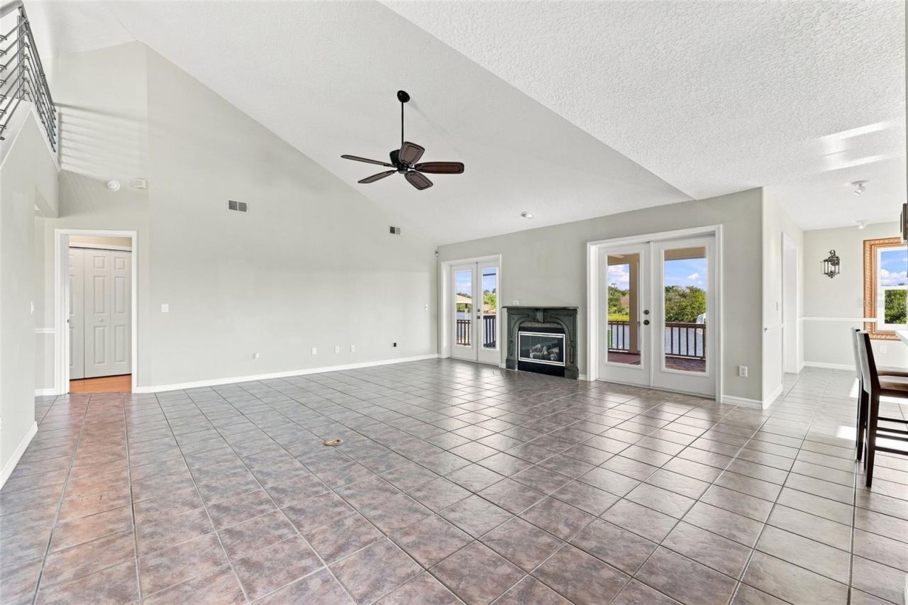 Photo 12 of 20: Great room — Vaulted great room with gas fireplace, French doors opening to twin water-view balconies, and tile flooring throughout.