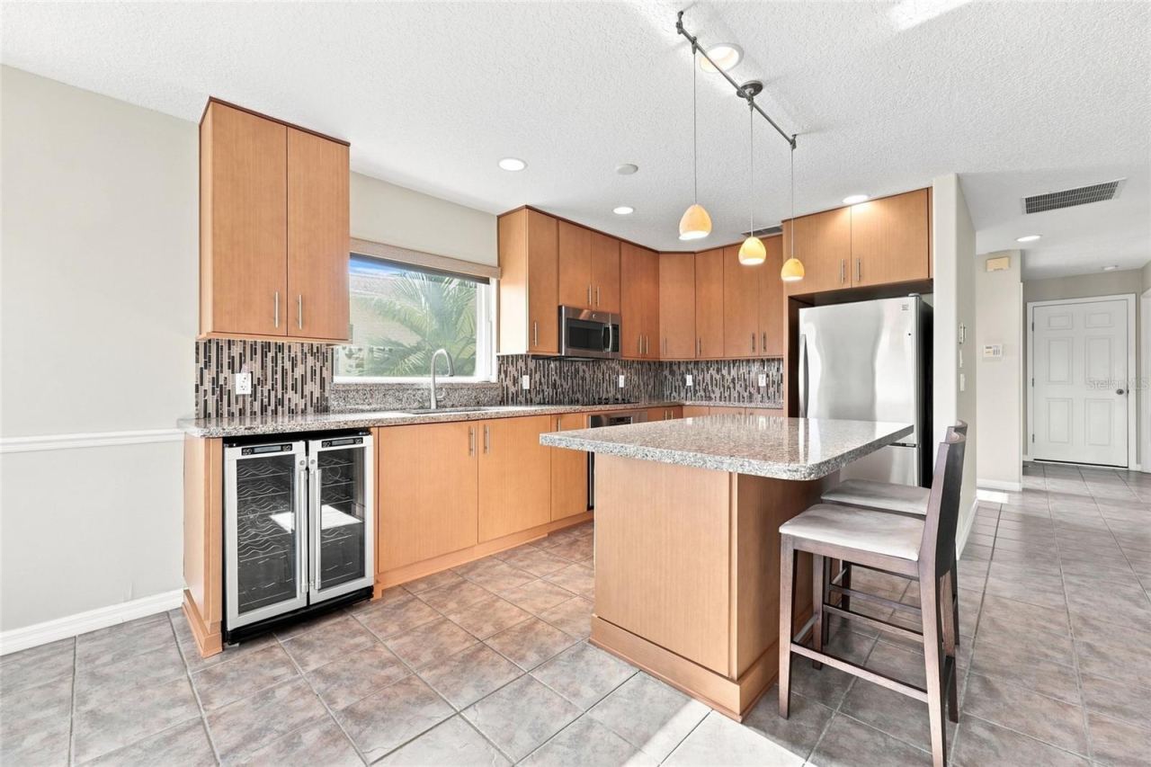 Photo 15 of 20: Kitchen — Kitchen with dual built-in wine and beverage refrigerators, granite countertops, and stainless appliances.
