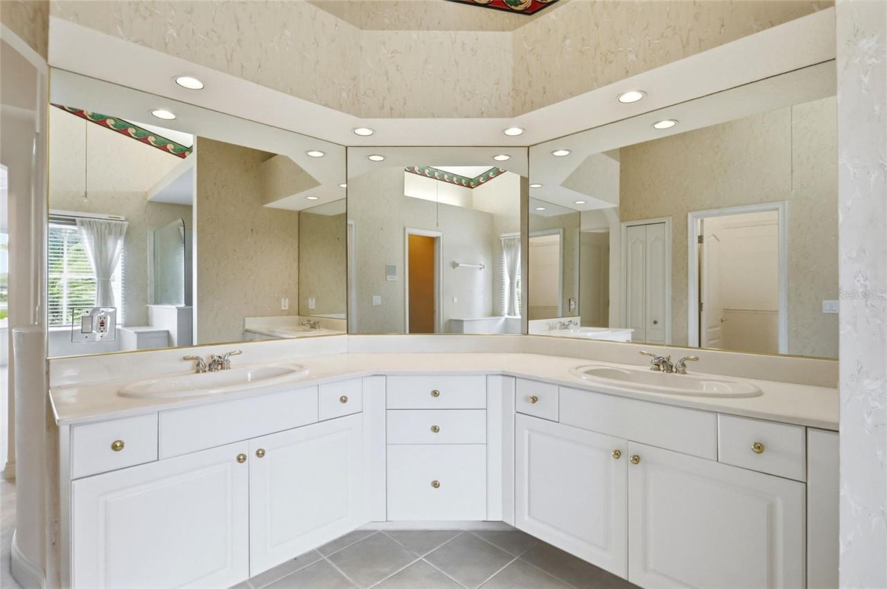 Photo 16 of 20: Dual-sink vanity with generous counter space and cabinet storage in the primary bathroom.