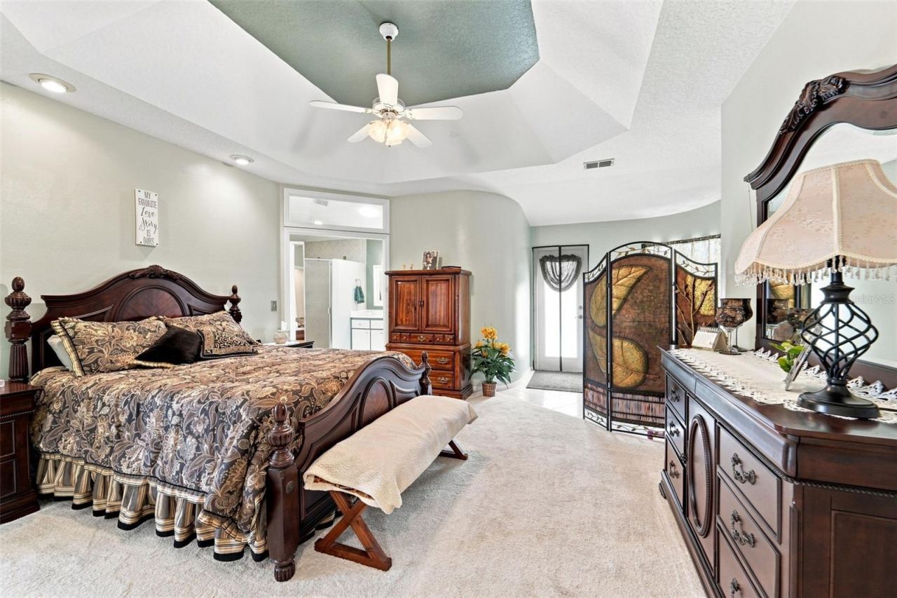 Photo 5 of 20: Large primary bedroom with ensuite bathroom, walk-in closet and a convenient sitting area near the pool deck entrance.
