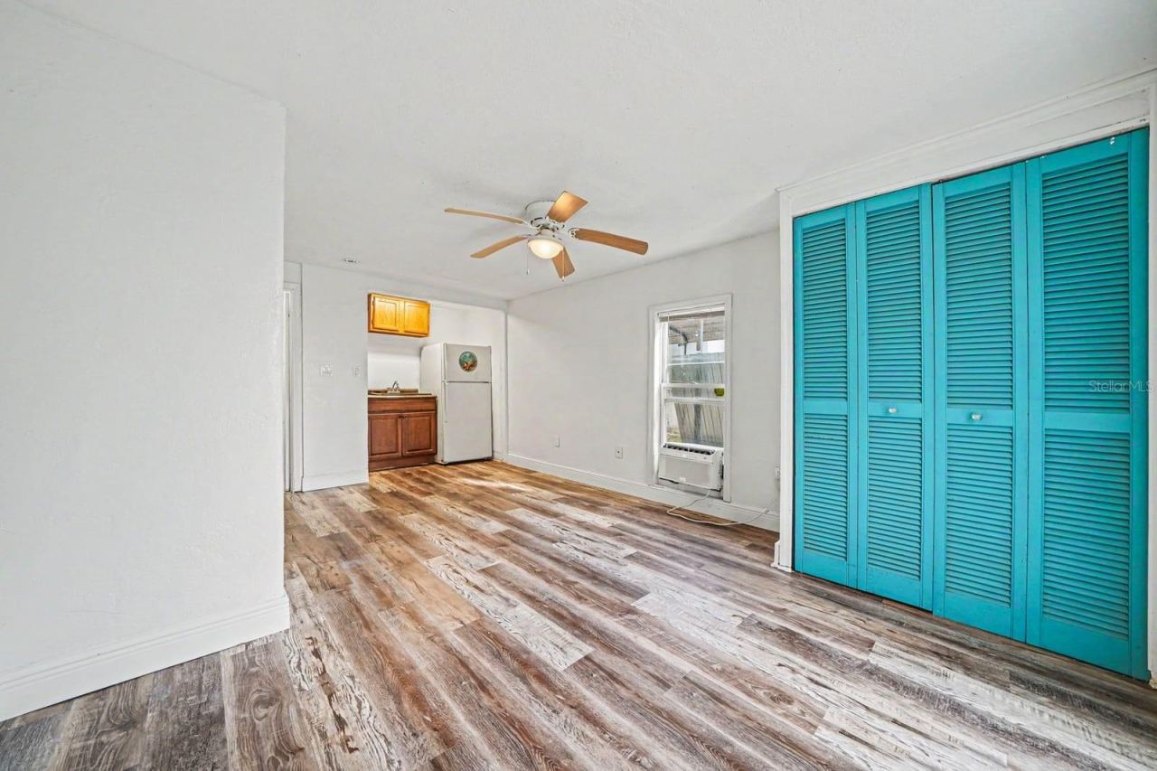 Photo 19 of 20: Bright Bedroom with Turquoise Closets, Wood Floors & Multiple Windows