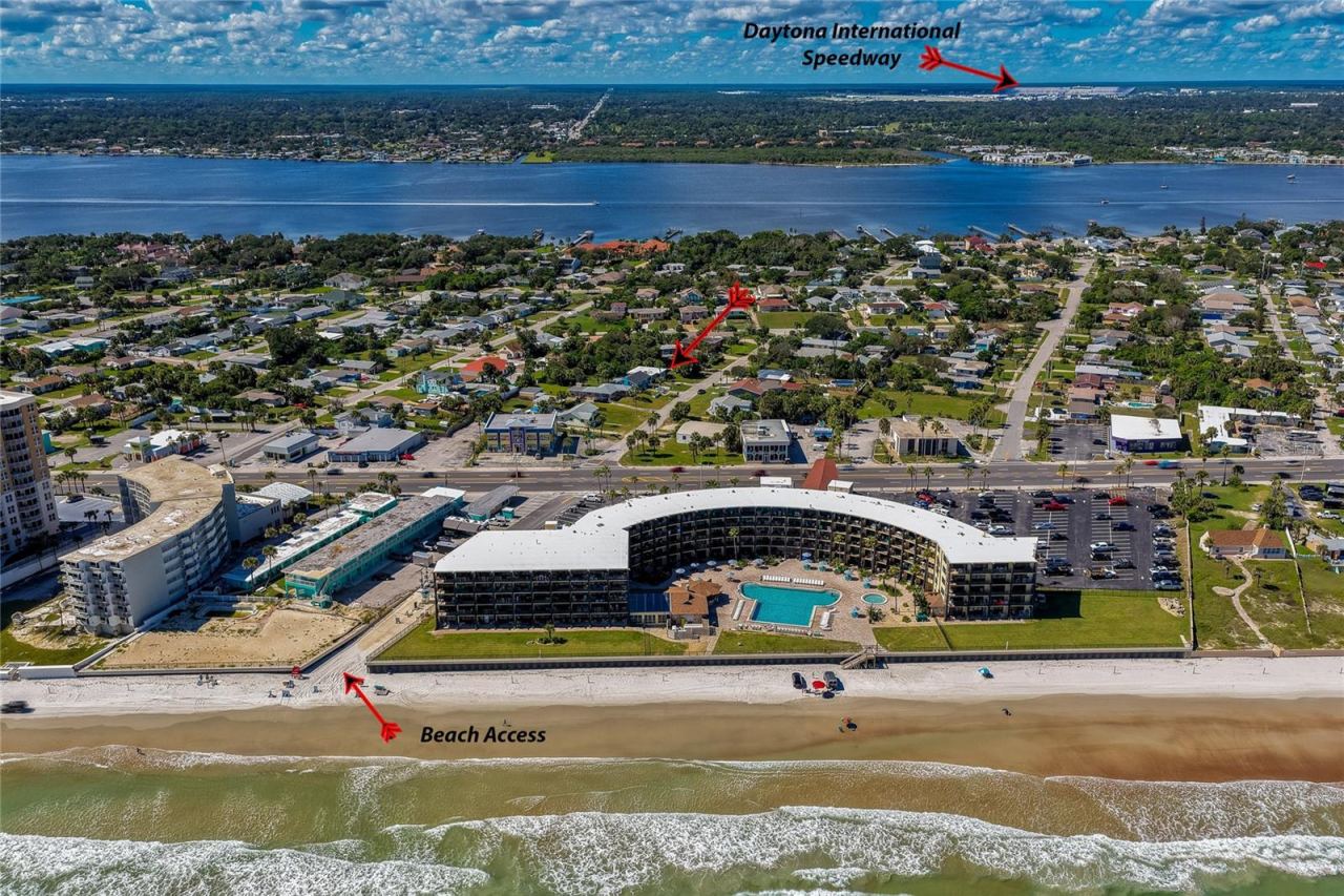 Photo 3 of 20: Broad coastal aerial showcase indicating key regional landmarks, including direct beach access routes and the nearby Daytona International Speedway. The surrounding area offers easy access to local amenities and beachside attractions.