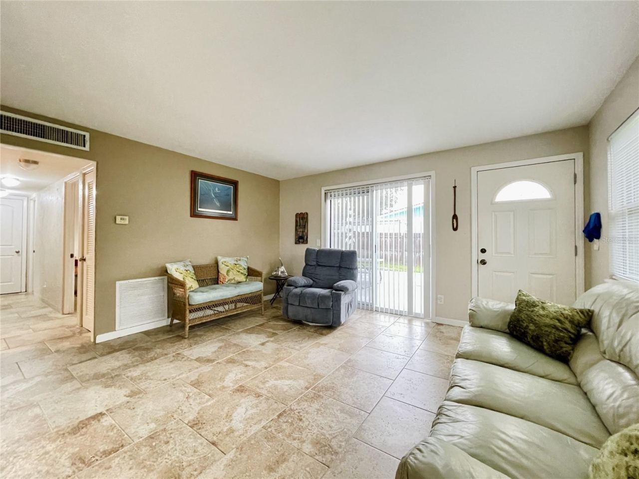 Photo 7 of 20: Sunlit living space highlighting a sliding glass door that leads to the backyard.