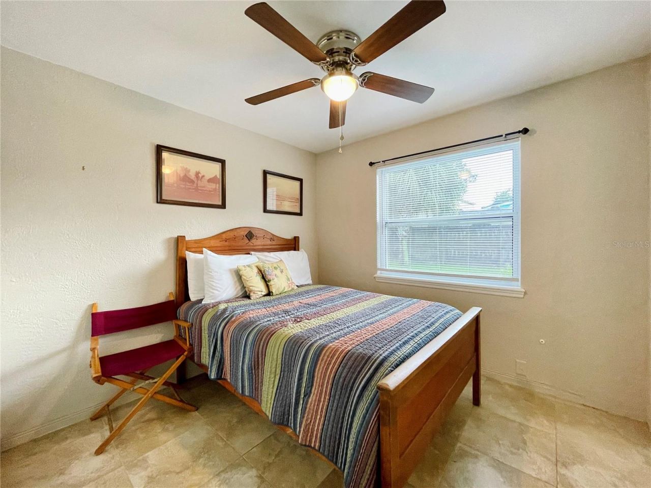 Photo 17 of 20: Cozy bedroom featuring a ceiling fan and large window.