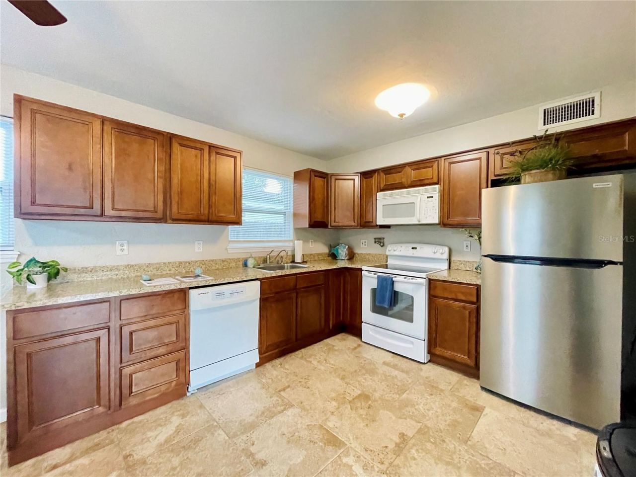 Photo 10 of 20: Fully equipped, efficient kitchen showcasing ample countertops and classic wood cabinets.