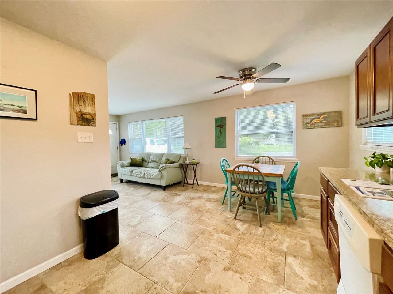 Photo 13 of 20: The kitchen and dining area flow naturally into the adjacent living space, creating an open, connected layout with multiple windows providing plenty of natural light.