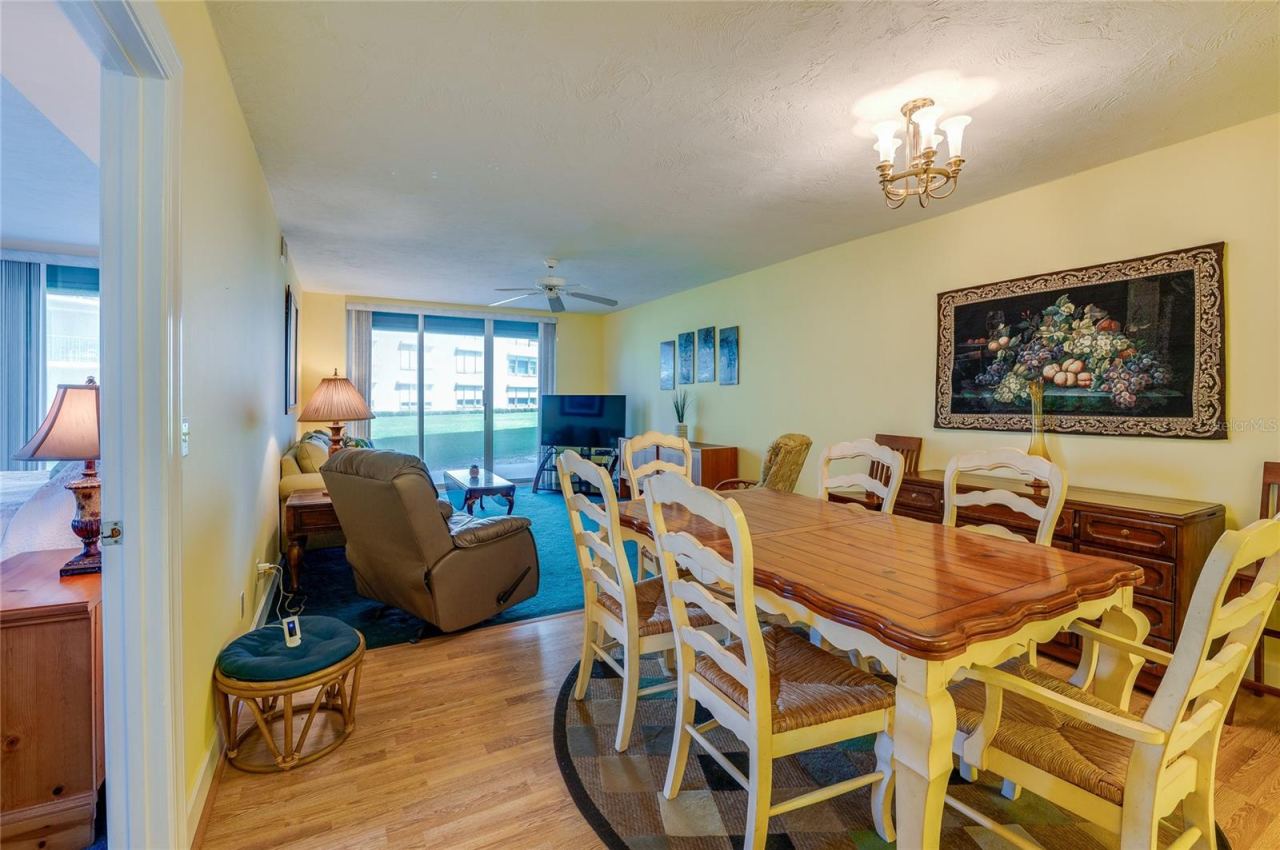 Photo 17 of 20: The combined living and dining area offers a spacious layout with large sliding glass doors that bring in natural light and provide access to outdoor views, ideal for both relaxing and hosting.