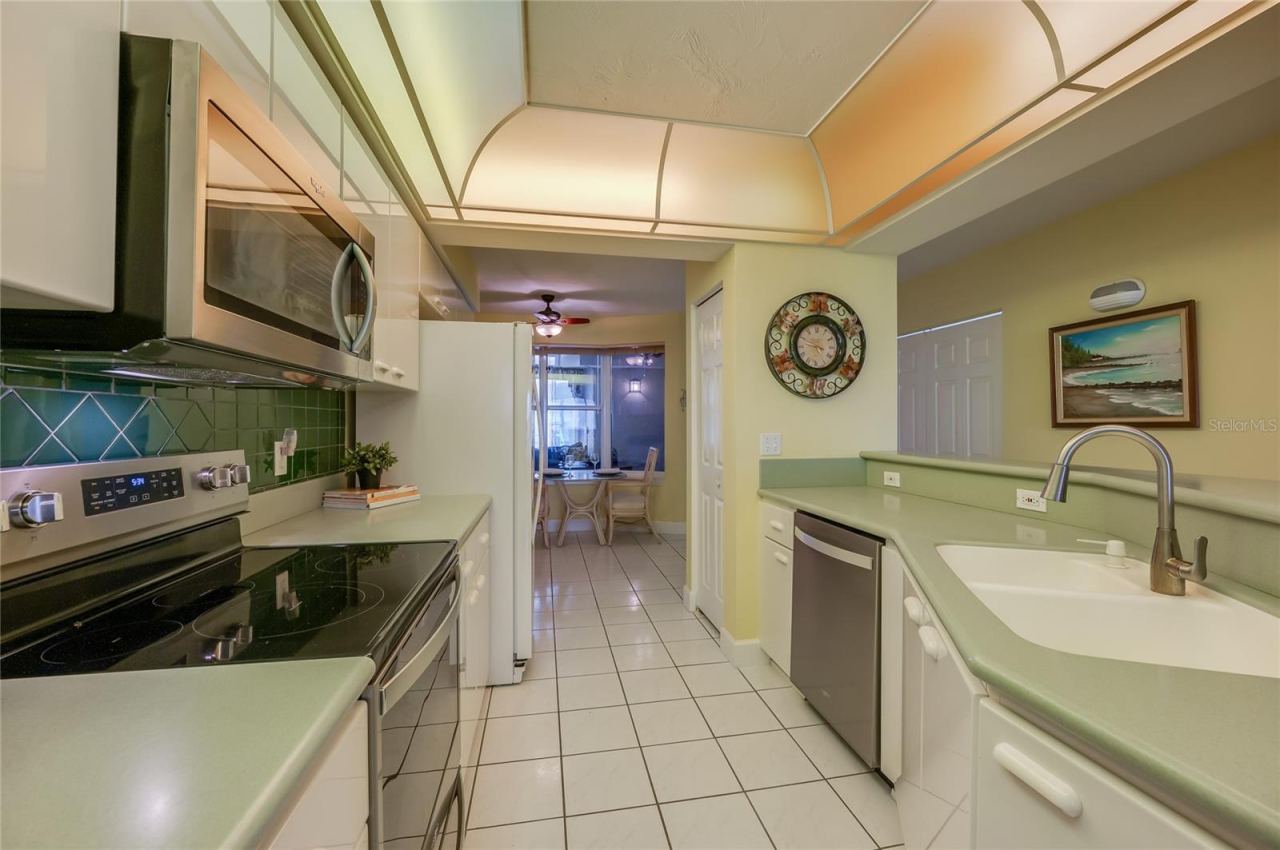 Photo 14 of 20: This perspective highlights the open design and sink area, allowing for easy interaction between the kitchen and living/dining spaces.