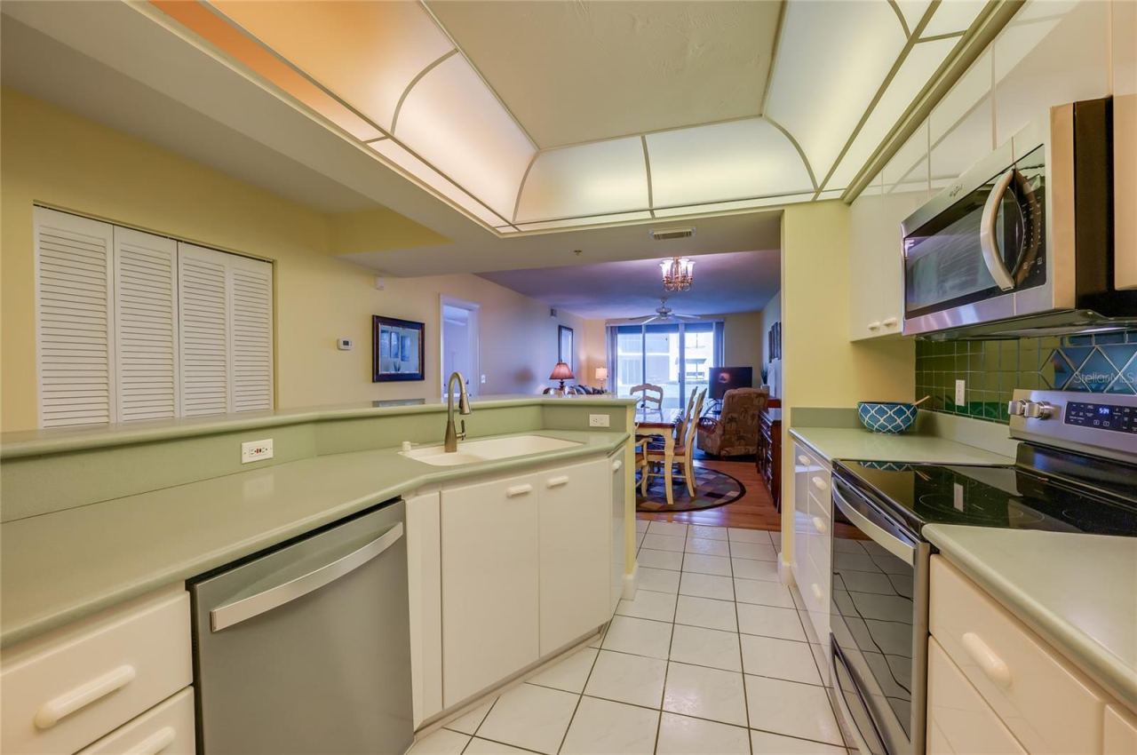 Photo 15 of 20: A reverse view showcases the kitchen’s efficient layout, breakfast bar seating, and open connection to the main living areas.