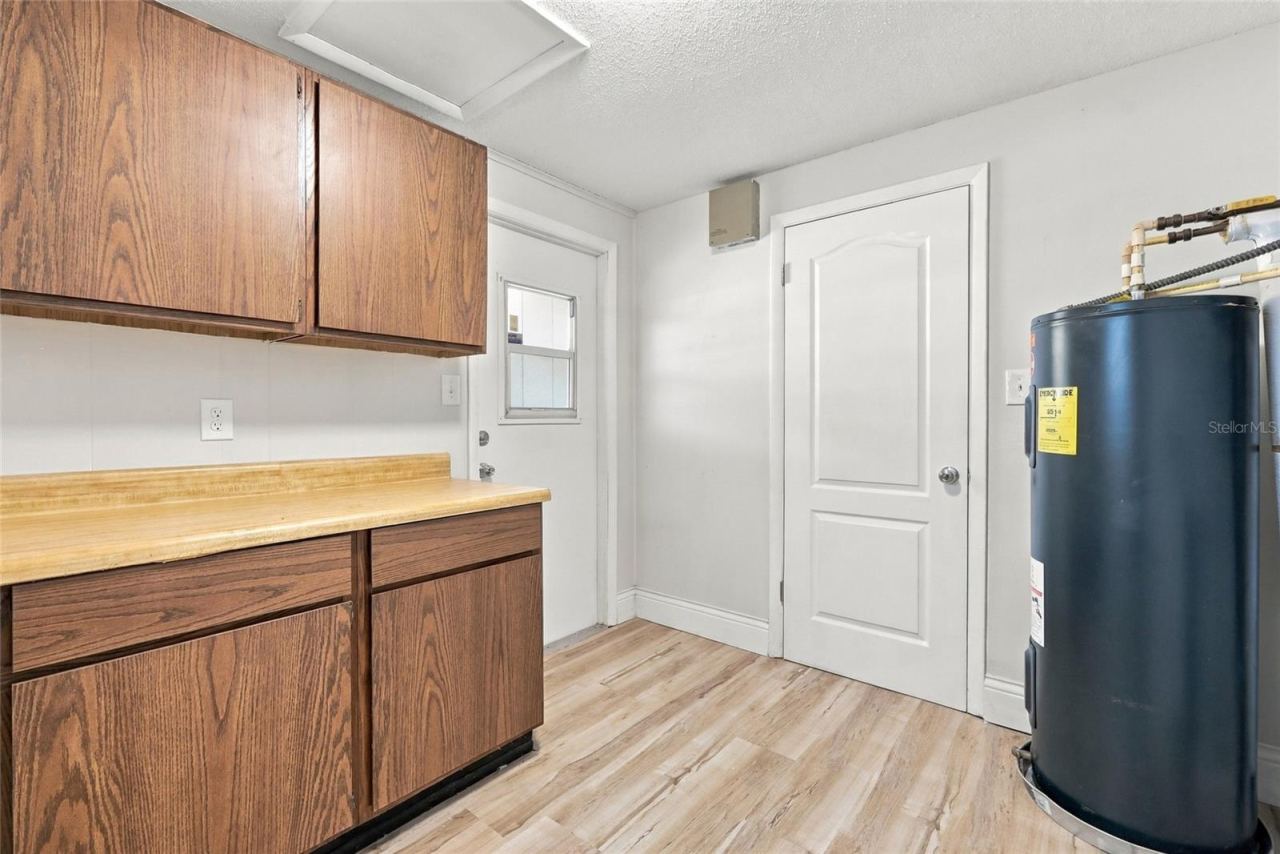 Photo 18 of 20: Inside utility with cabinets with left door to carport and other to dining area.