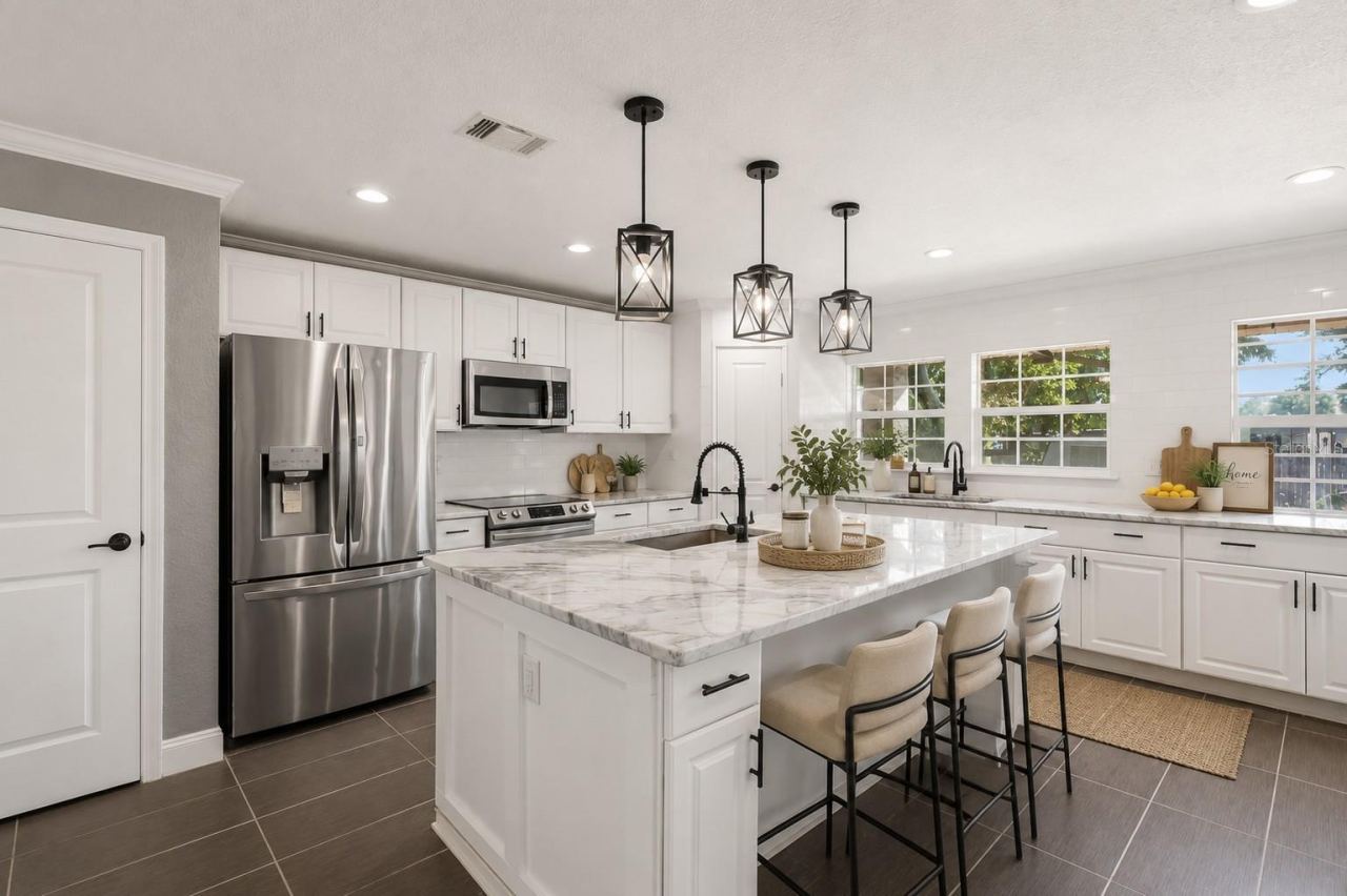 Photo 10 of 20: Main House Updated Kitchen with granite countertops, oversized island with gray marble countertops, custom cabinetry, 2 pantries, and ALL brand-new stainless steel appliances