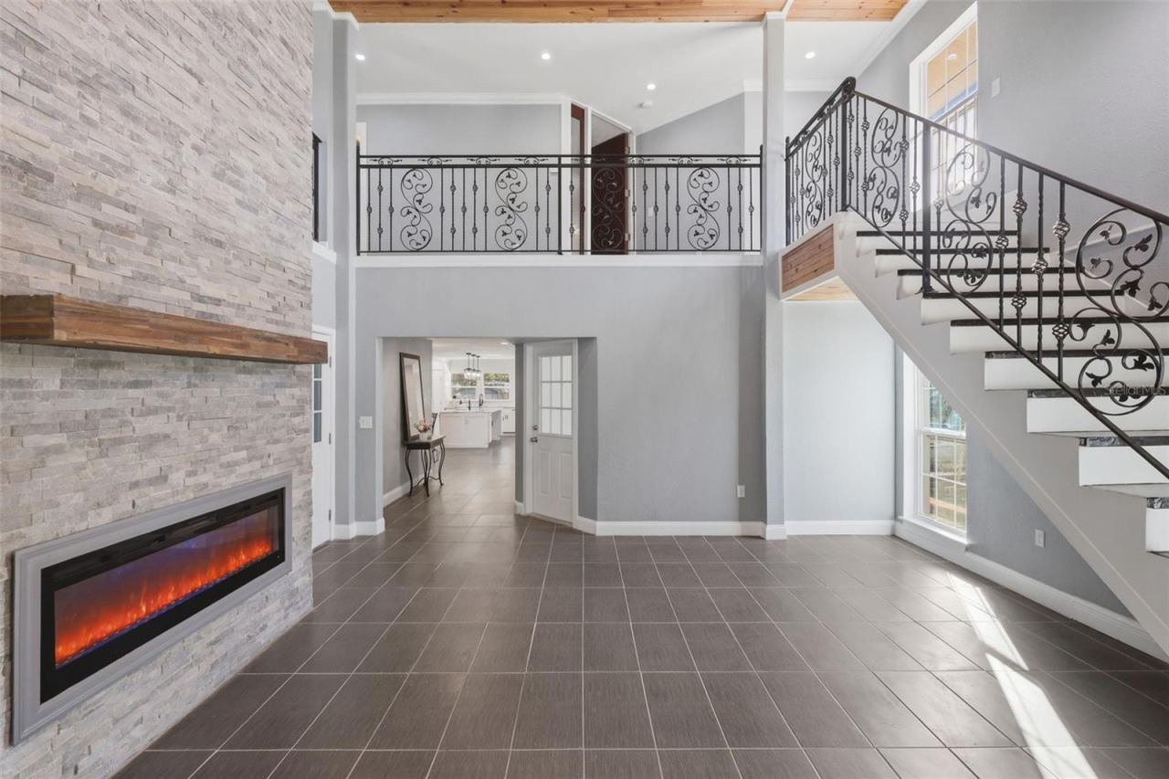 Photo 5 of 20: Main Living Area with floor to ceiling fireplace mantel and custom wrought- iron staircase leading all the way up to the Third floor.