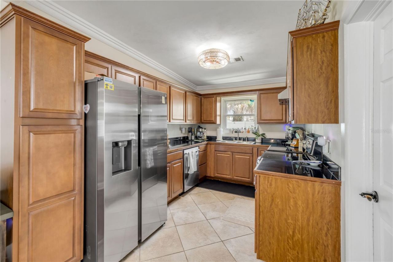 Photo 3 of 20: Kitchen with wood cabinetry and stainless-steel appliances.