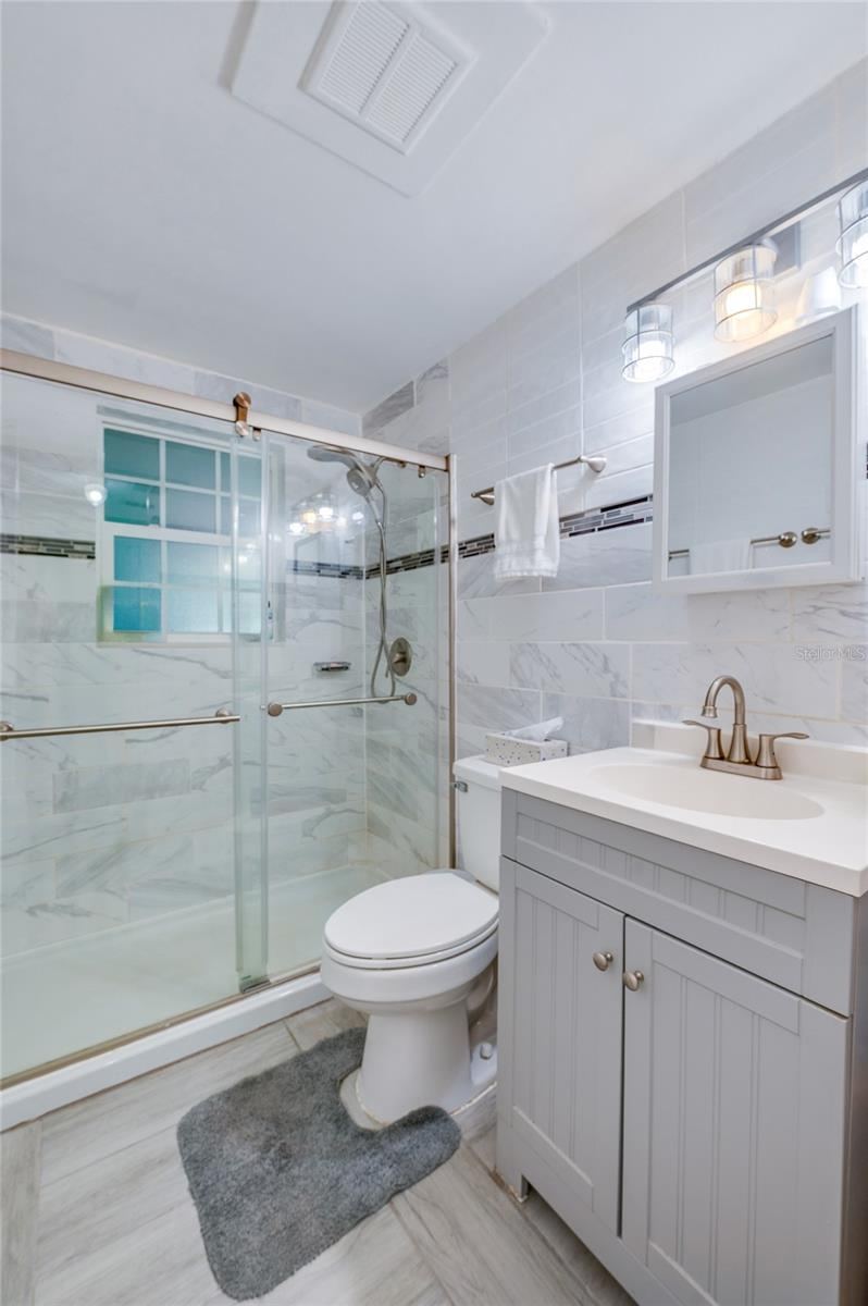 Photo 19 of 20: Remodeled bathroom with floor to ceiling tile