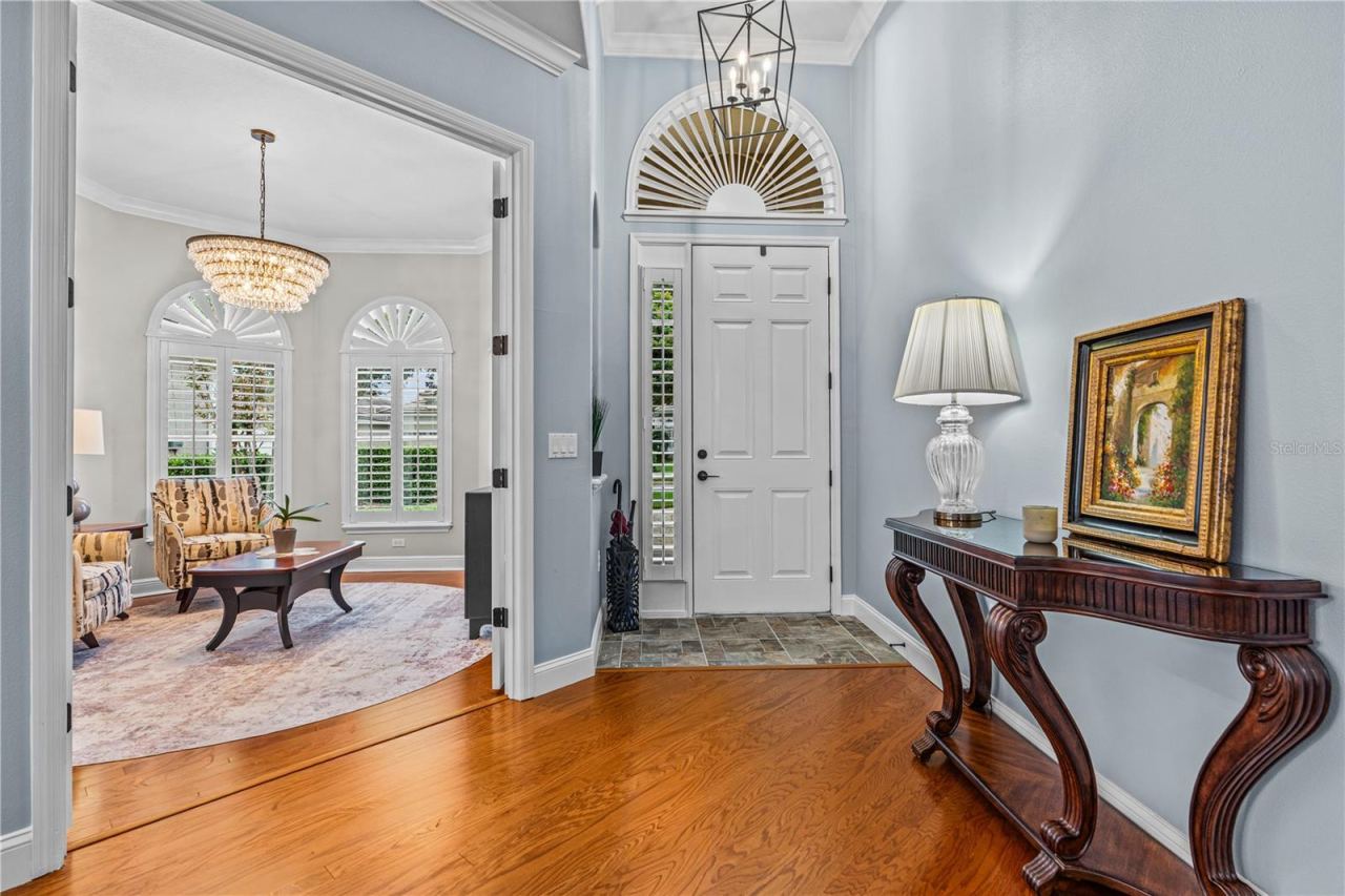 Photo 7 of 20: In the foyer looking toward the front door with the pretty arched transom window and into the front den/office through the open French doors