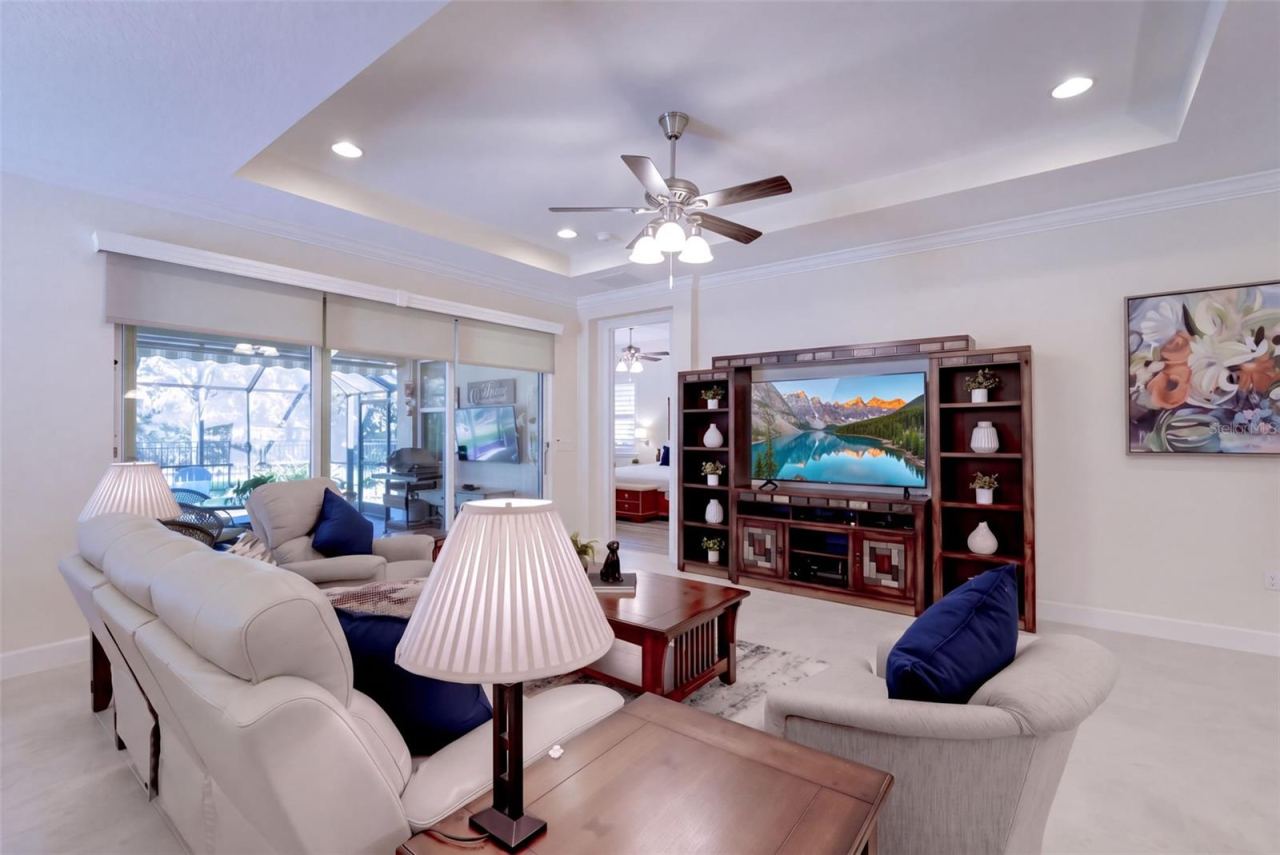 Photo 9 of 20: 15'6" x 18' Great Room w/ tray ceiling, recessed lighting, crown molding & remote controlled shades for the sliding glass doors