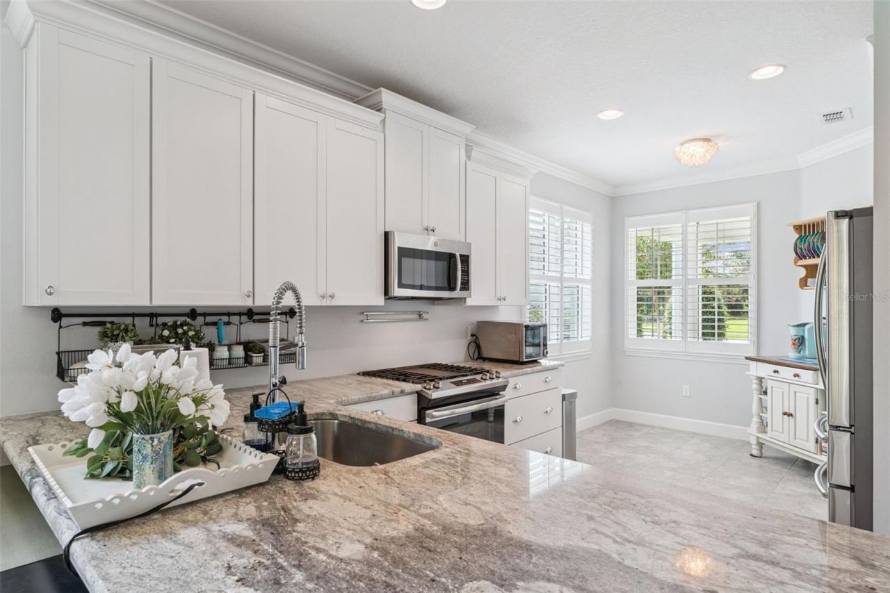 Photo 5 of 20: Kitchen w/ a single basin undermount stainless steel sink, 5-burner natural gas range & Plantation style shutters