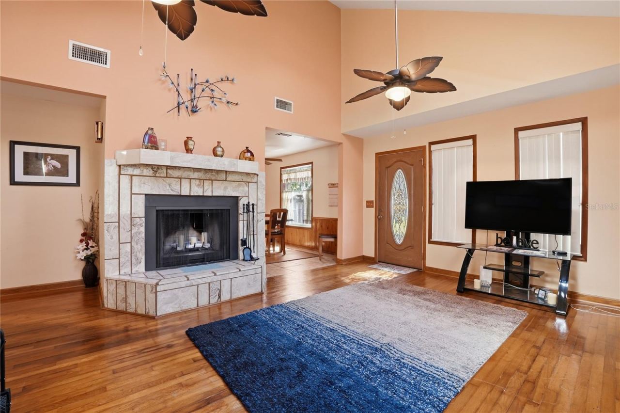 Photo 4 of 20: Living room with high ceiling, sky lights, real wood floors and beautiful wood-burning fireplace.
