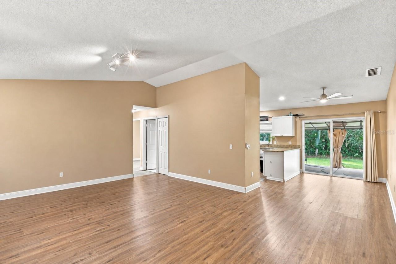 Photo 2 of 20: Great room with access to kitchen and patio access.