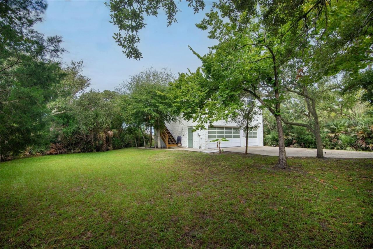 Photo 8 of 20: Left side of the property out front with sideview of house showing the garage entry, the stairs and the chairlift to the second floor living area