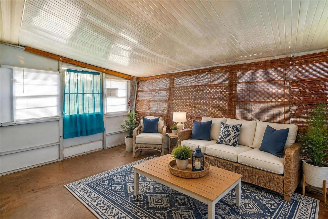 Photo 19 of 20: Virtually Staged - Expansive enclosed porch offers a flexible bonus space with numerous windows and woven shades for filtered natural light.