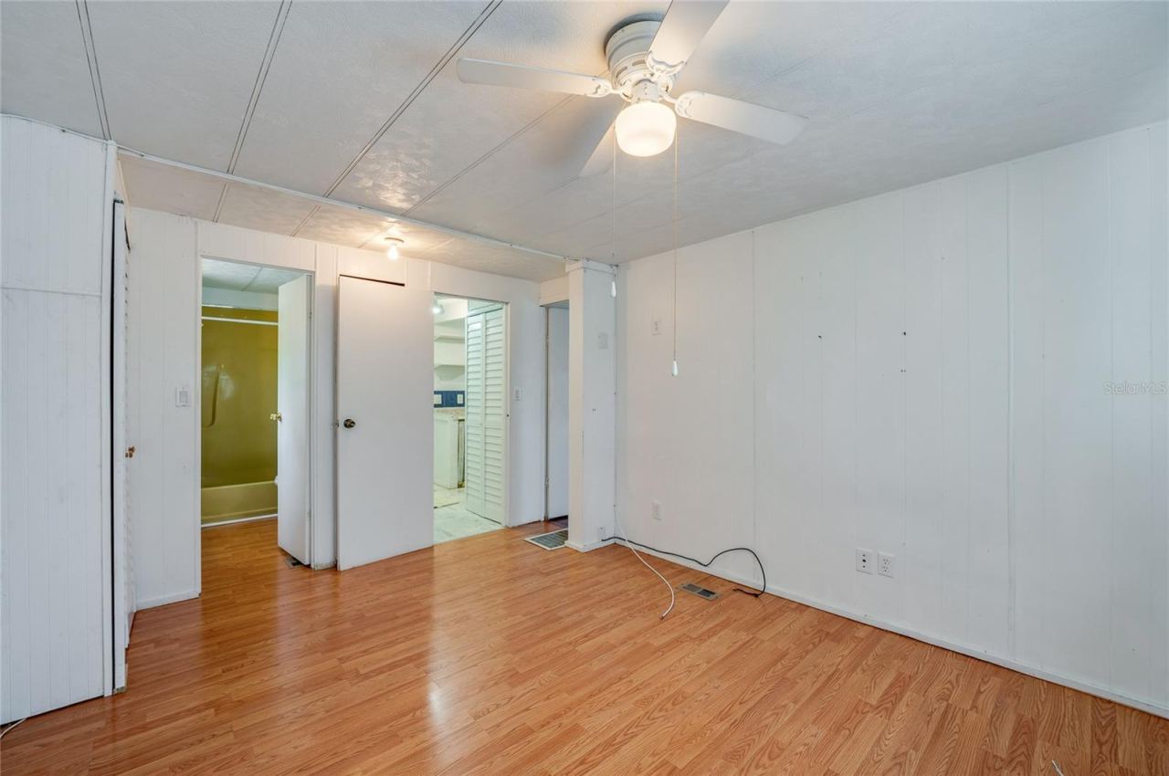 Photo 15 of 20: Another view highlights the room’s generous open floor area, ceiling fan, and convenient access to the adjoining bath and nearby living spaces.