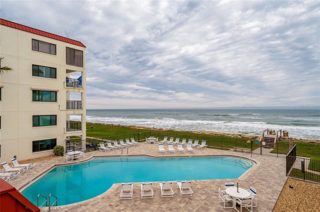 Photo 4 of 20: The oceanfront pool area features ample seating, a paved sun deck, and gated access to the beach—designed for relaxing and recreation.