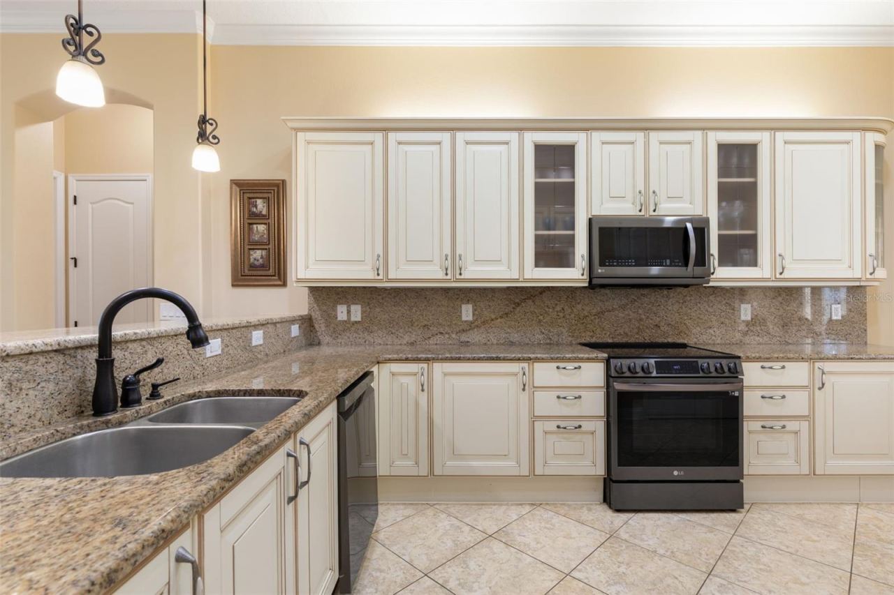 Photo 6 of 20: Italian-inspired cabinetry, granite countertops and matching backsplash bring timeless elegance to this beautifully designed kitchen.