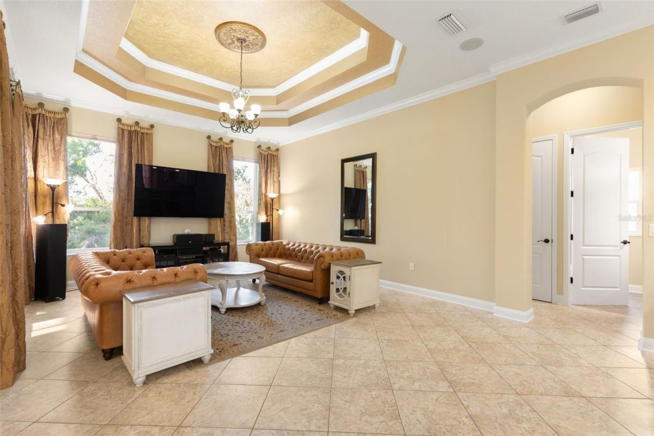 Photo 11 of 20: An elegant gathering room where a dramatic tray ceiling, crown molding and decorative lighting create a beautiful setting for relaxing and entertaining.