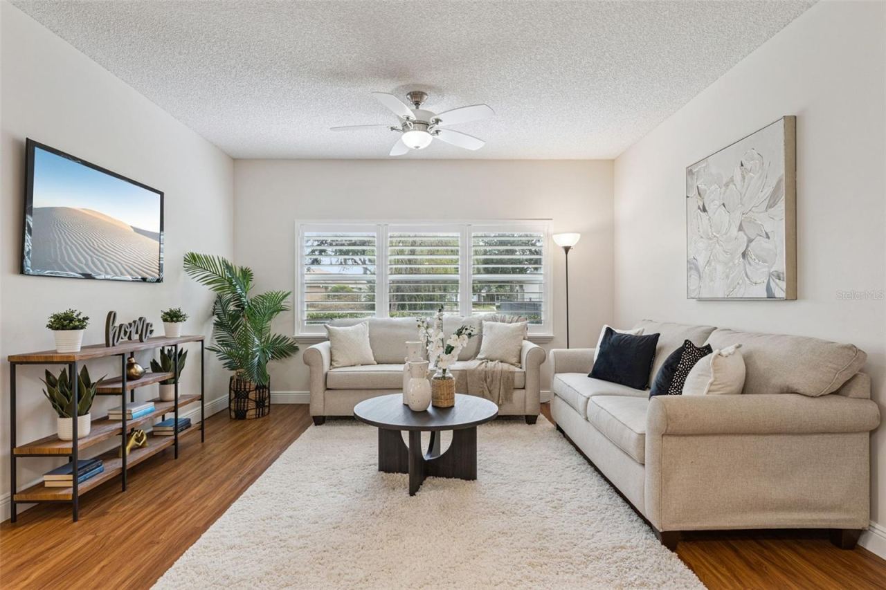 Photo 13 of 20: 14' x 13' Family Room w/ laminate floor, ceiling fan & Plantation style shutters