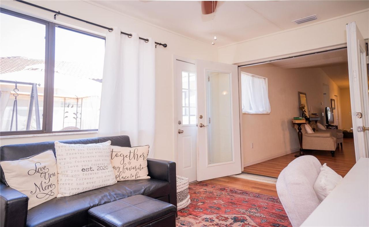 Photo 14 of 20: The view from the office space looking through the French doors into the living room, featuring a seamless flow to the outdoor patio—perfect for entertaining.