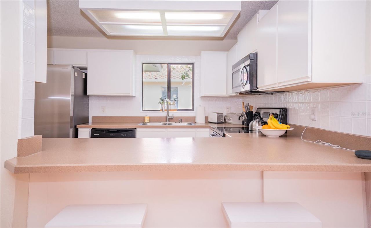 Photo 15 of 20: This bright and airy kitchen is the heart of the home, featuring abundant natural light and a convenient breakfast bar.