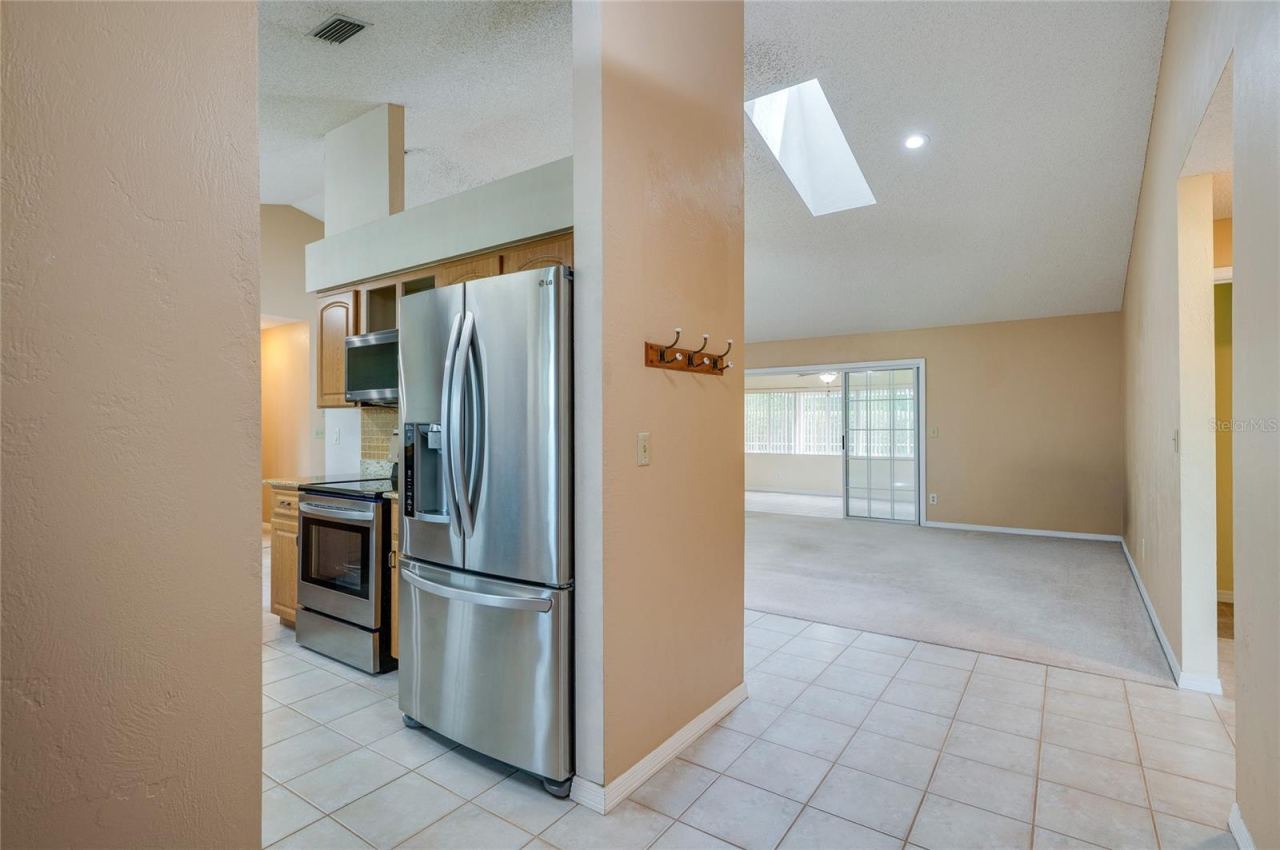 Photo 7 of 20: Functional kitchen nook outfitted with stainless steel appliances, modern tiling, and recessed lighting. Skylights overhead enhance the bright, open interior feel.